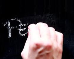mano che scrive con il gesso sulla lavagna
