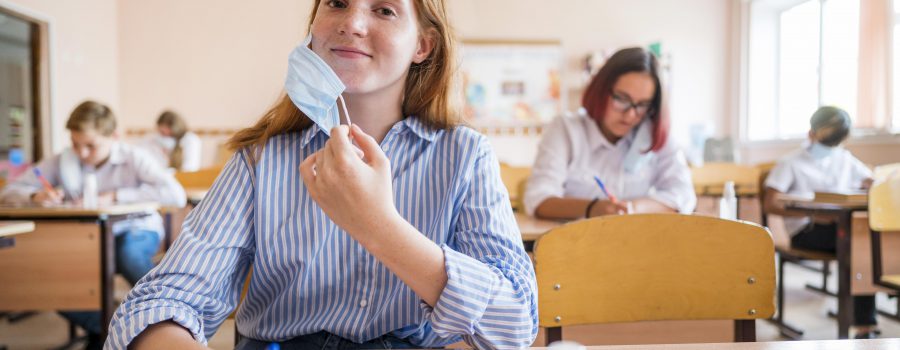 primo piano di uno studente con mascherina all'interno della classe